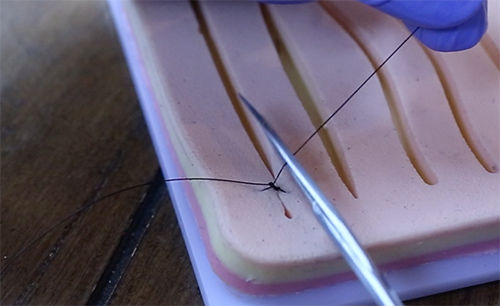 Cutting extra thread with the help of needle.