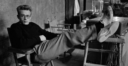 A man sitting on a chair with his feet up in a casual style.