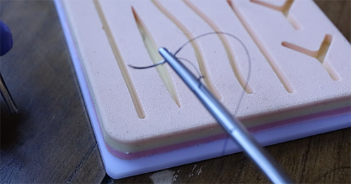 Needle holder with a thread.