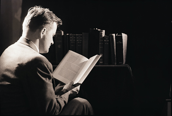 A man in a suit reading more books.