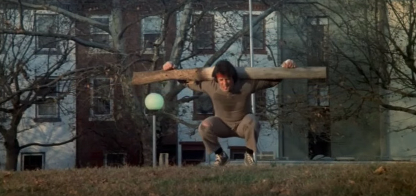 Rocky doing frog jumps with a log on his neck.