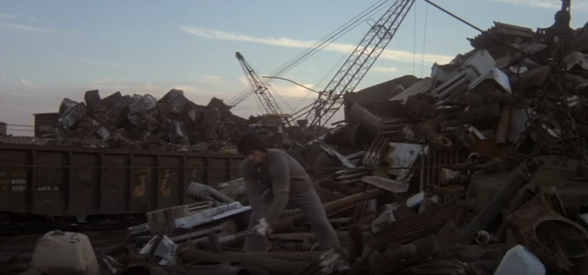 Rocky hitting junk with a sledgehammer.