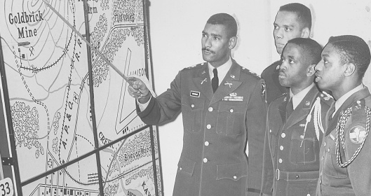 A group of men in military uniforms, led by a true leader, inspecting a map.