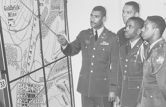 A group of men in military uniforms, led by a true leader, inspecting a map.