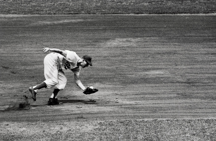 Baseball player caught a ball while running.