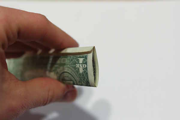 Closeup view of one dollar bill in hand.
