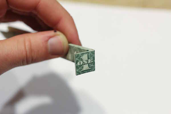 Closeup view of folded one dollar bill from edge.