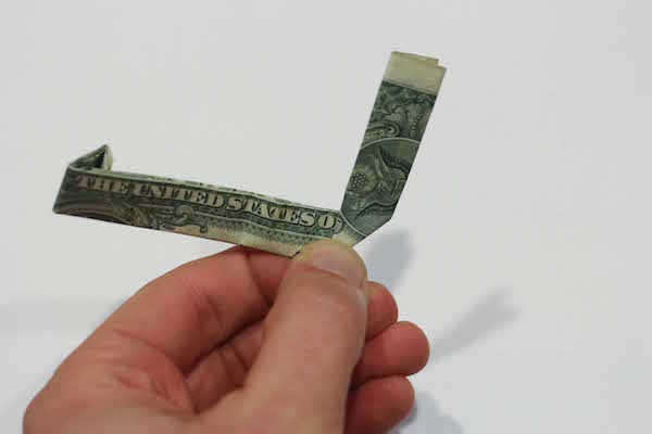 Folded dollar bill with one side faced upward.