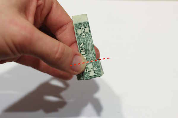 One American dollar curled up by hand.