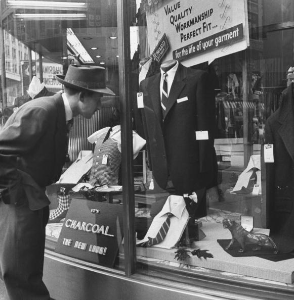Vintage man looking at suite in a shop from window. 