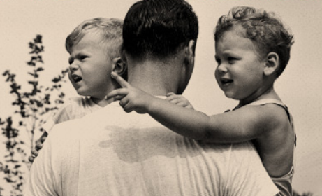 A black and white photo of a father and his two sons showcasing parenthood.
