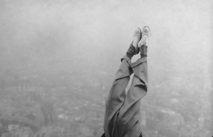 A man performing a handstand on a fence with grace and balance.