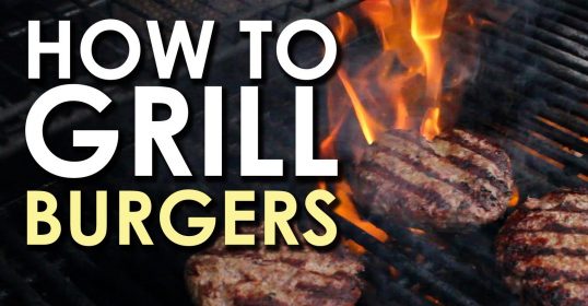 A burger grilling on the grill during summer.
