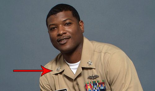 Navy soldier in uniform with ranking pins on both collars.