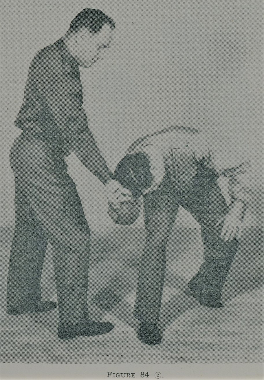 Grasping opponent's hand while moving down during self defense.