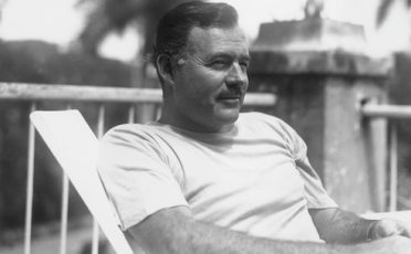 A black and white photo of a man sitting in a chair.