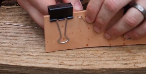 A man sewing a leather.