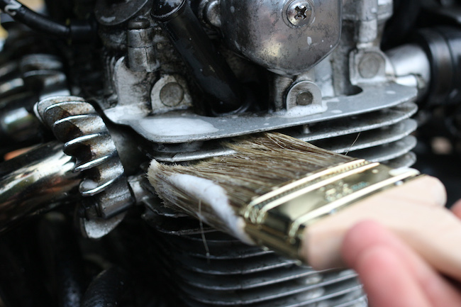 Cleaning the engine with brush.