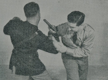 Two men in uniform engaged in unarmed combat during WWII.