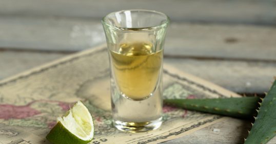 A shot of tequila with a slice of lime, perfect for a man.