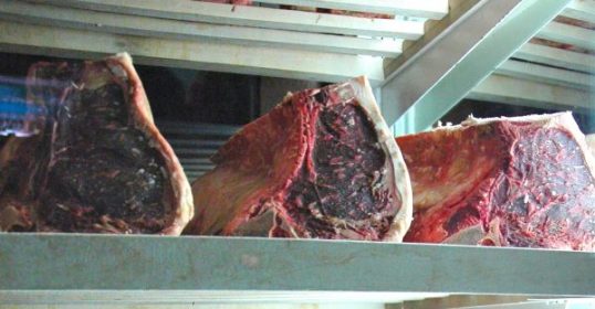 A display of dry-aged beef on a shelf.