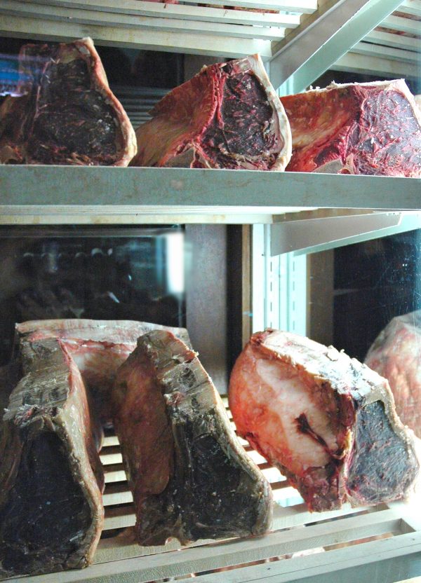 A display of dry-aged beef on a shelf.