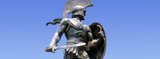 A statue of a Spartan warrior holding a shield, embodying the Spartan Way.