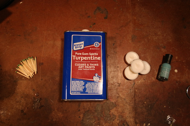 Matches, masking tape, turpentine, small metal, nail polish, candles and small container for storage displayed.