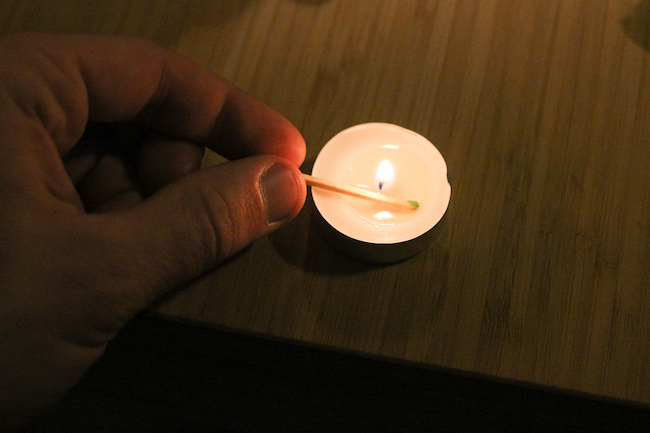 Matchstick getting dipped in candle wax.