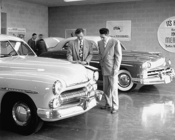 Two vintage men buying a brand new car from a company.
