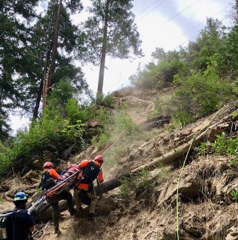 Rescue team carrying person on a stretcher.