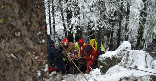 A group of rescuers from a search and rescue team in a snowy area.