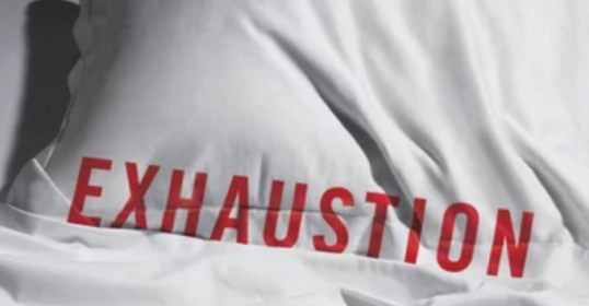 A modern pillow with the word exhaustion written on it.