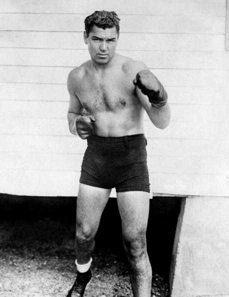 Jack Dempsey em ilustração a preto e branco com luvas de boxe.