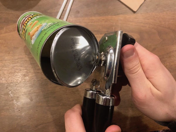 Removing the bottom of Pringles can with can opener.