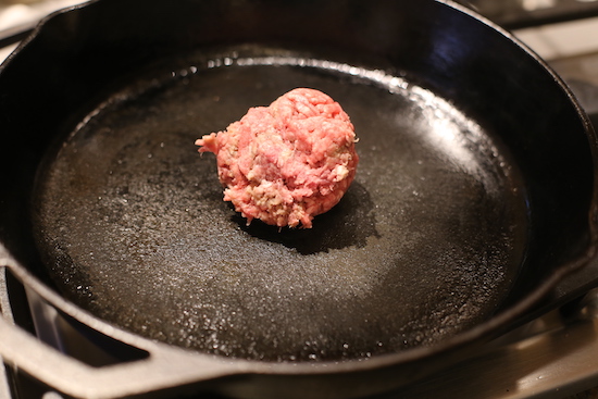 Scoop of beef in a hot skillet.