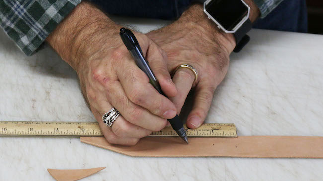 Measuring the leather strip by scale and pen.