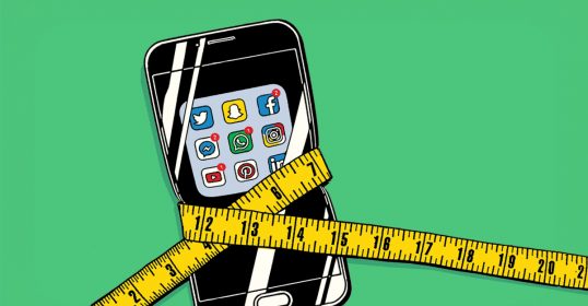 A smartphone with a measuring tape around it, perfect for tracking social media trends.