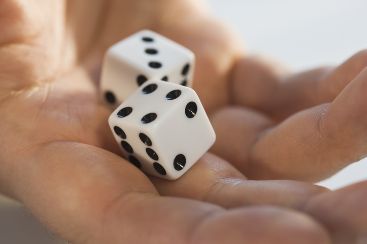Two white dice in a person's hand, potentially bringing some luck.