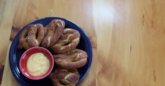 A plate of pretzels with dipping sauce, perfect for the ballpark.