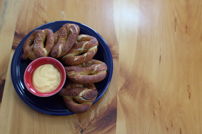 A plate of pretzels with dipping sauce, perfect for the ballpark.