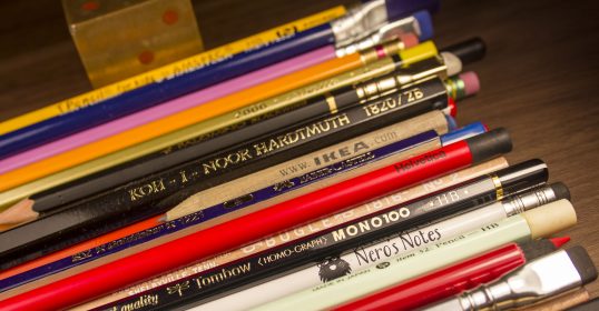 A group of colored pencils on a table.