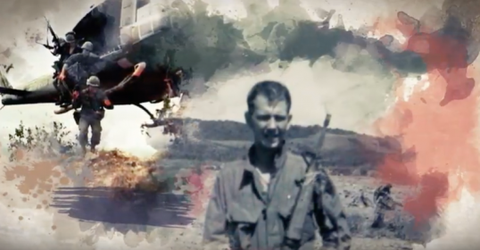 A man in a military uniform stands next to a helicopter, possibly wearing the Medal of Honor.