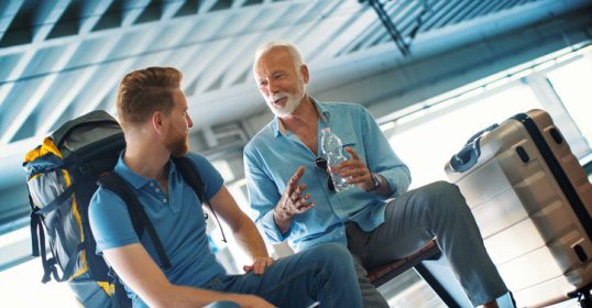 A man and a woman engage in conversation at an airport.