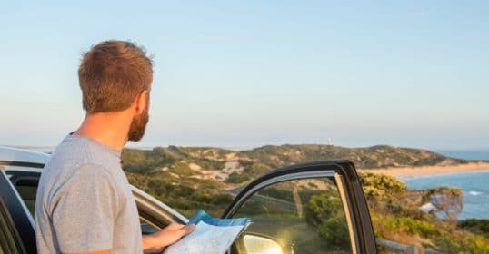 The bearded man looked out of his car window at the ocean.