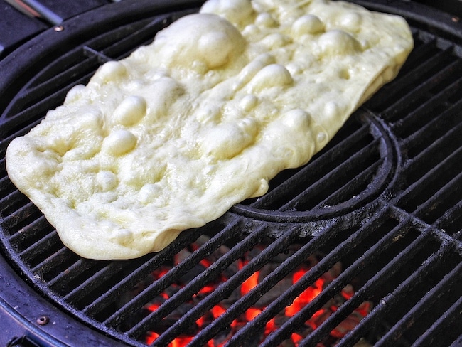 Pizza dough getting grilled. 