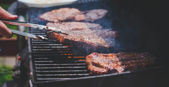 A person is grilling the perfect steak on a grill.