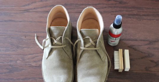 A man's shoe cleaning set with a brush and shoe polish.