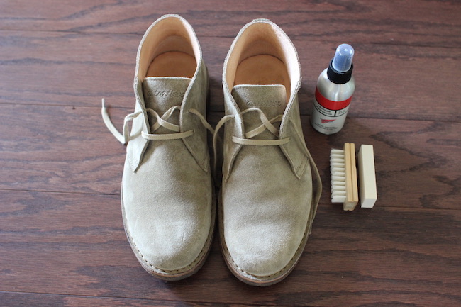 A man's shoe cleaning set with a brush and shoe polish.
