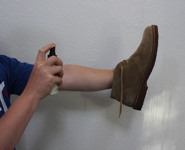 Spraying leather protector on suede shoes.